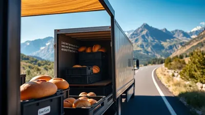 Bäckereilieferwagen fährt auf einer Straße mit Gebirge im Hintergrund.